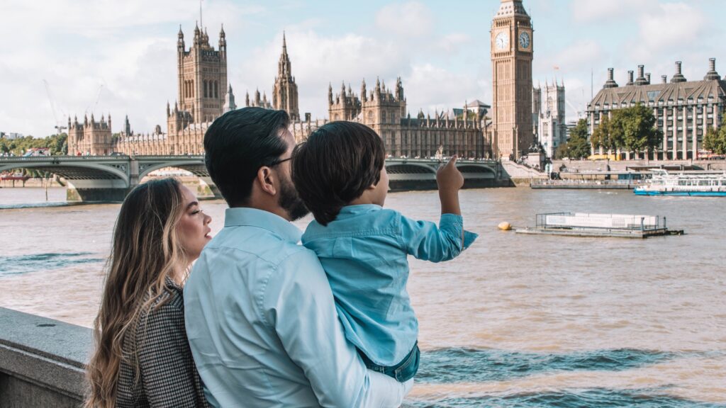 A family looking out over the River Thames with Big Ben and the Houses of Parliament in the background. Taken on a sunny summer day.